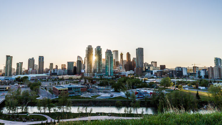 The Calgary skyline at dusk seen across the river valley